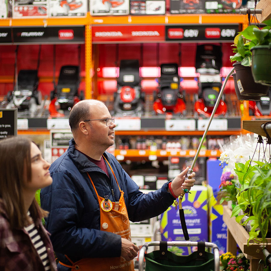 Service recipient watering plants at Home Depot